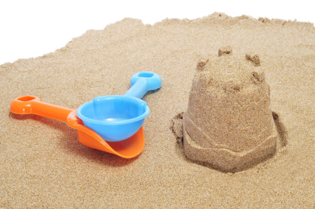 a sandcastle on the sand and each shovels