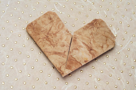 old paper heart on a patterned background