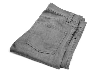 folded gray denim trousers on a white backgroundの写真素材
