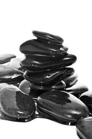 a pile of balanced zen stones covered with water on a white backgroundの写真素材