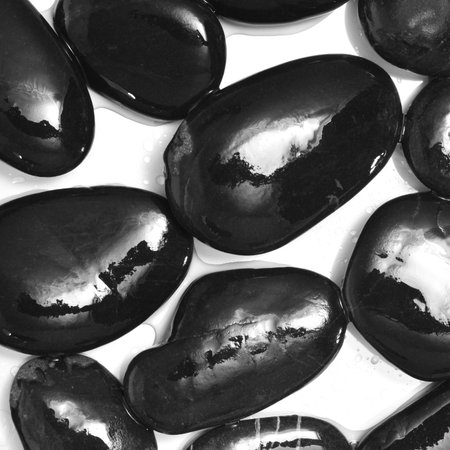 closeup of a pile of wet stones on a white backgroundの写真素材