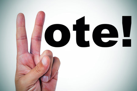 a man hand making the V sign to complete the sentence vote  written in black