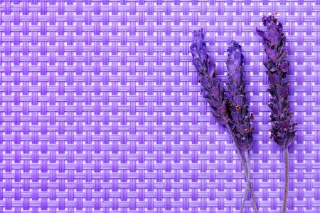 some lavender flowers on a purple woven backgroundの写真素材