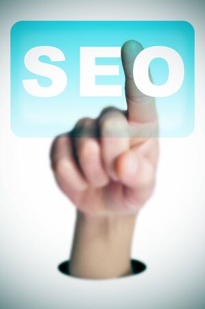 a man finger clicking on a button with the word SEO written in it on a transparent screenの写真素材