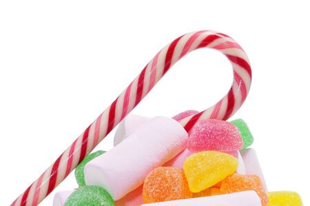 a pile of candies, such as candy canes, marshmallows or gumdrops, on a white backgroundの写真素材