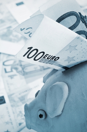 a 100 euro bill in a piggy bankの写真素材
