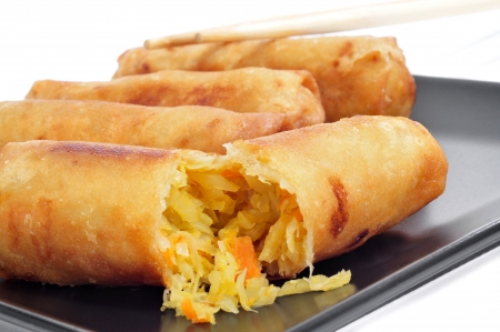 closeup of a plate with some spring rolls on a white backgroundの写真素材