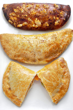 closeup of some different empanadas, cakes stuffed with vegetables and or meat or tuna, on a white backgroundの写真素材