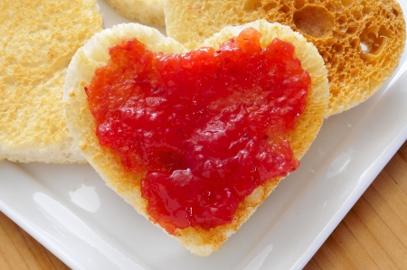 closeup of a plate with heart-shaped toasts and strawberry jamの写真素材