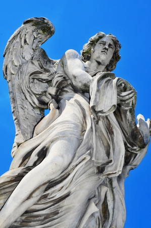 seventeenth century statue depicting the Angel with Garment and Dice, in Ponte Sant Angelo or Aelian Bridge in Rome, Italyの写真素材