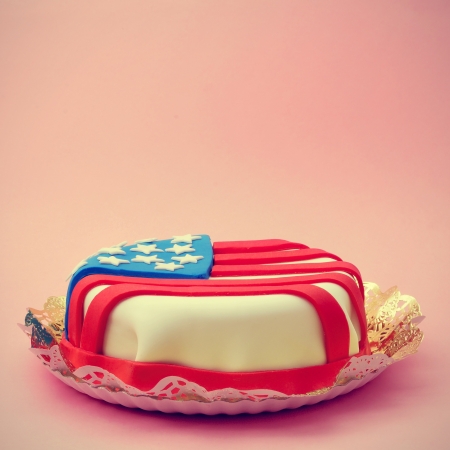 closeup of a cake decorated with the american flag, on a pink background, with a retro effectの写真素材