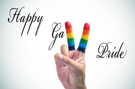 sentence happy pride and a man hand making a Y with his fingers painted as the rainbow flag, on a white backgroundの写真素材