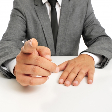 man wearing a suit sitting in a table pointing the finger to the observerの写真素材