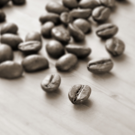 closeup of a pile of roasted coffee beans on a wooden table, in black and whiteの写真素材