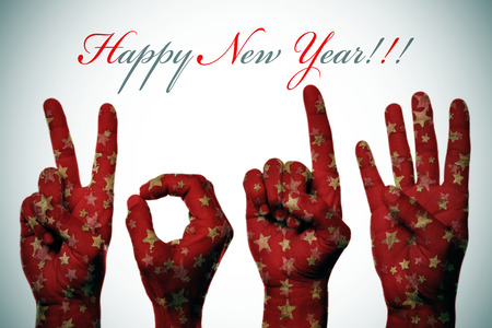 sentence happy new year and hands patterned with golden christmas stars forming number 2014 の写真素材