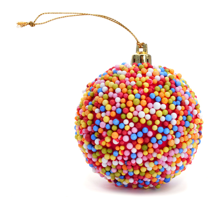 a christmas ball coated with nonpareils of different colors on a white backgroundの写真素材