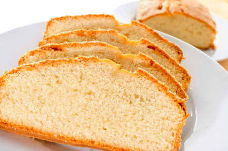 closeup of a plate with some slices of sponge cake on a table