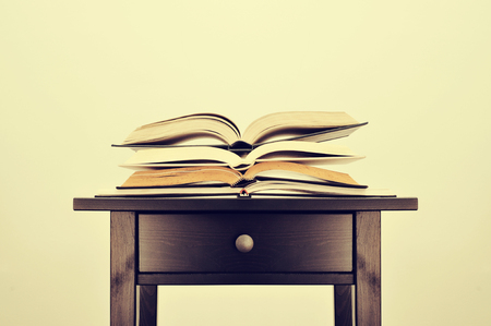 a pile of books on a desk symbolizing the concept of reading habit or studyingの写真素材