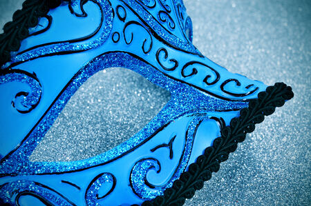 an elegant blue and black carnival mask on a sparkling blue backgroundの写真素材
