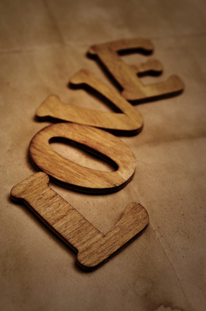 wooden letters forming the word love on an old paper backgroundの写真素材
