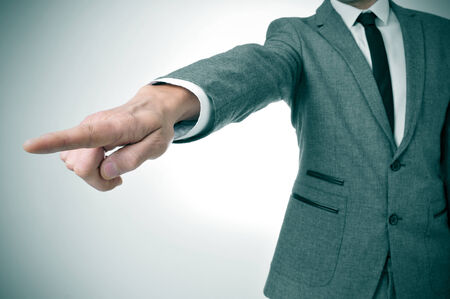 a man wearing a suit pointing with the finger the way outの写真素材