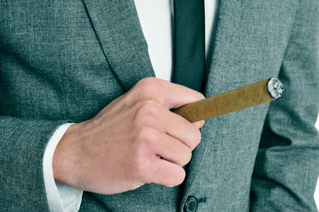 a man wearing a suit smoking a cigarの写真素材