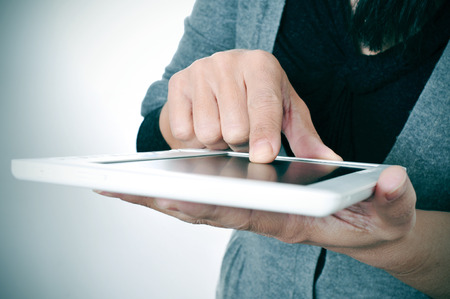 a woman in casual wear using a tablet computerの写真素材