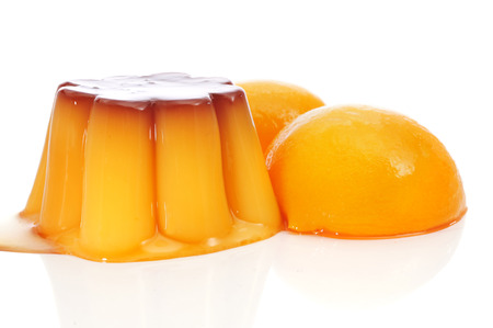 creme caramel and peach in syrup on a white backgroundの写真素材