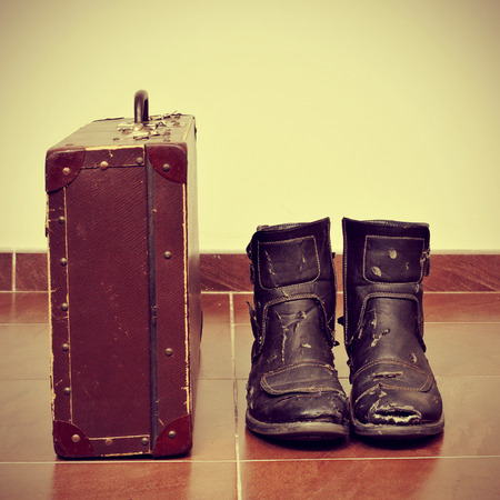 picture of an old suitcase and a pair of worn boots with a retro effectの写真素材