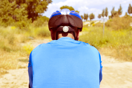 a young man riding a mountain bike on a dirt roadの写真素材