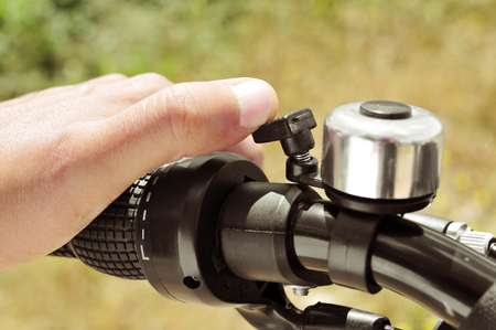 closeup of the hand of a man ringing a bicycle bellの写真素材