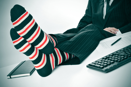 a businessman relaxing in the office with his feet on the deskの写真素材
