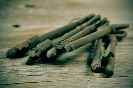 some old and rusty keys on a rustic wooden tableの写真素材
