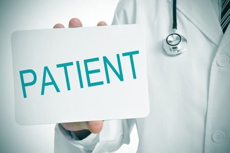 a doctor showing a signboard with the word patient written in itの写真素材