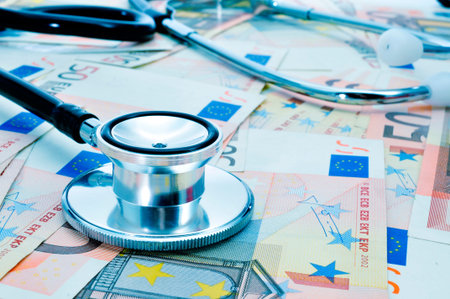 a stethoscope on a pile of euro bills, depicting the health care industry conceptの写真素材