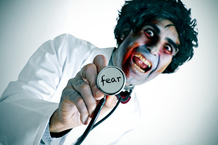 a scary zombie doctor with the word fear written in his stethoscopeの写真素材