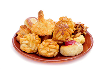 an earthenware plate with panellets, typical pastries of Catalonia, Spain, eaten in All Saints Day, on a white backgroundの写真素材
