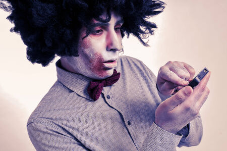 hipster zombie with an afro using a smartphone, with a filter effectの写真素材