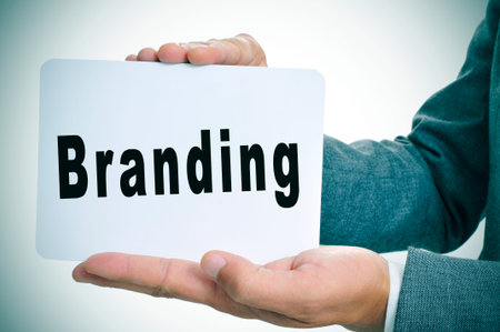 a man in suit showing a signboard with the word branding written in itの写真素材