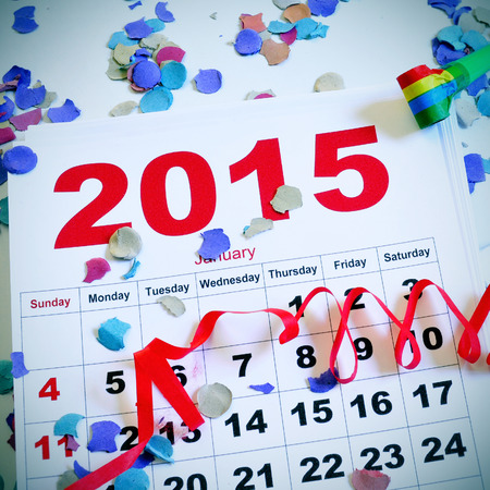 a january 2015 calendar on a white surface full of confetti, streamers and a party hornの写真素材