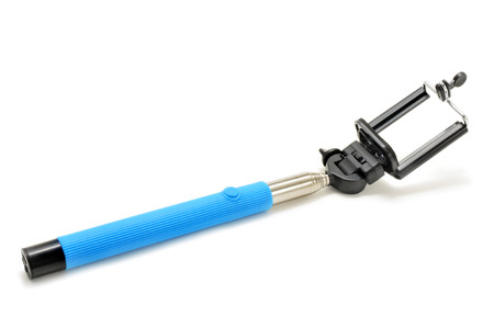 an extensible selfie stick with an adjustable clamp on the end on a white backgroundの写真素材