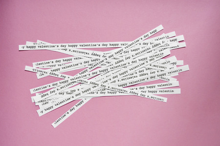 a lot of paper strips with the text happy valentines on a pink background, with a retro effectの写真素材