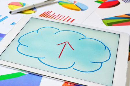 a drawing of a cloud with an arrow inside on the screen of a tablet, depicting the concept of upload...