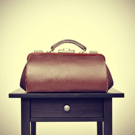 an old doctors bag on a table, with a retro filter effectの写真素材