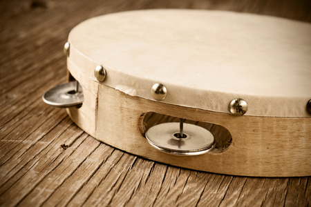 closeup of a tambourine on a rustic wooden table, heavy processing for retro bleached lookの写真素材