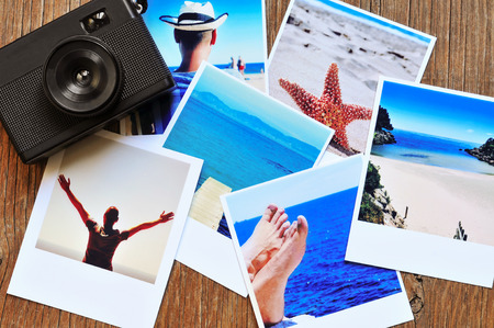 high-angle shot of a retro camera and some photos, shot by myself, of a young man at the beach and some of other beach scenes, placed on a rustic wooden tableの写真素材