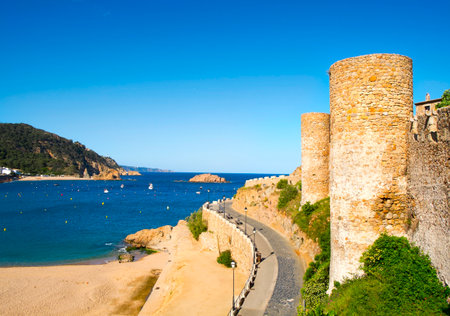 a view of the Platja Gran beach and the walls of the Vila Vella, the old town, of Tossa de Mar, Spainのeditorial素材