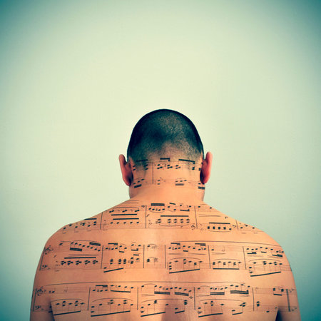 a young caucasian man with a musical score patterned in his back, with a retro effectの写真素材