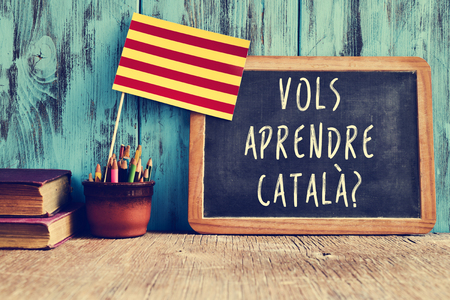a flag of Catalonia and a chalkboard with the question vols aprendre catala?, do you want to learn Catalan? written in Catalan in itの写真素材