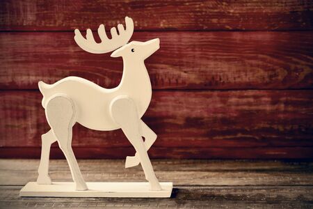 a wooden reindeer-shaped ornament on a rustic wooden surfaceの写真素材